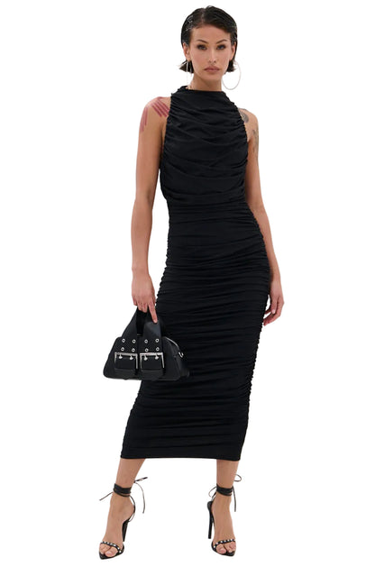 Woman wearing a black ruched dress holding a matching handbag on a white background