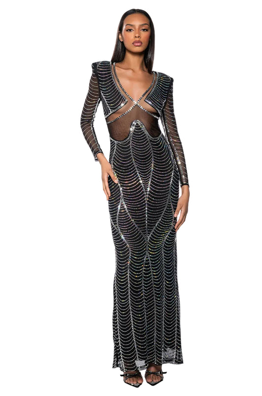 Woman wearing a black evening gown with sheer panels on a white background