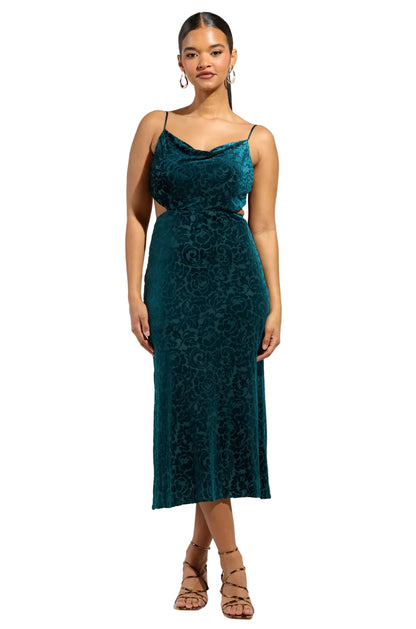 Woman wearing a teal lace dress against a plain background